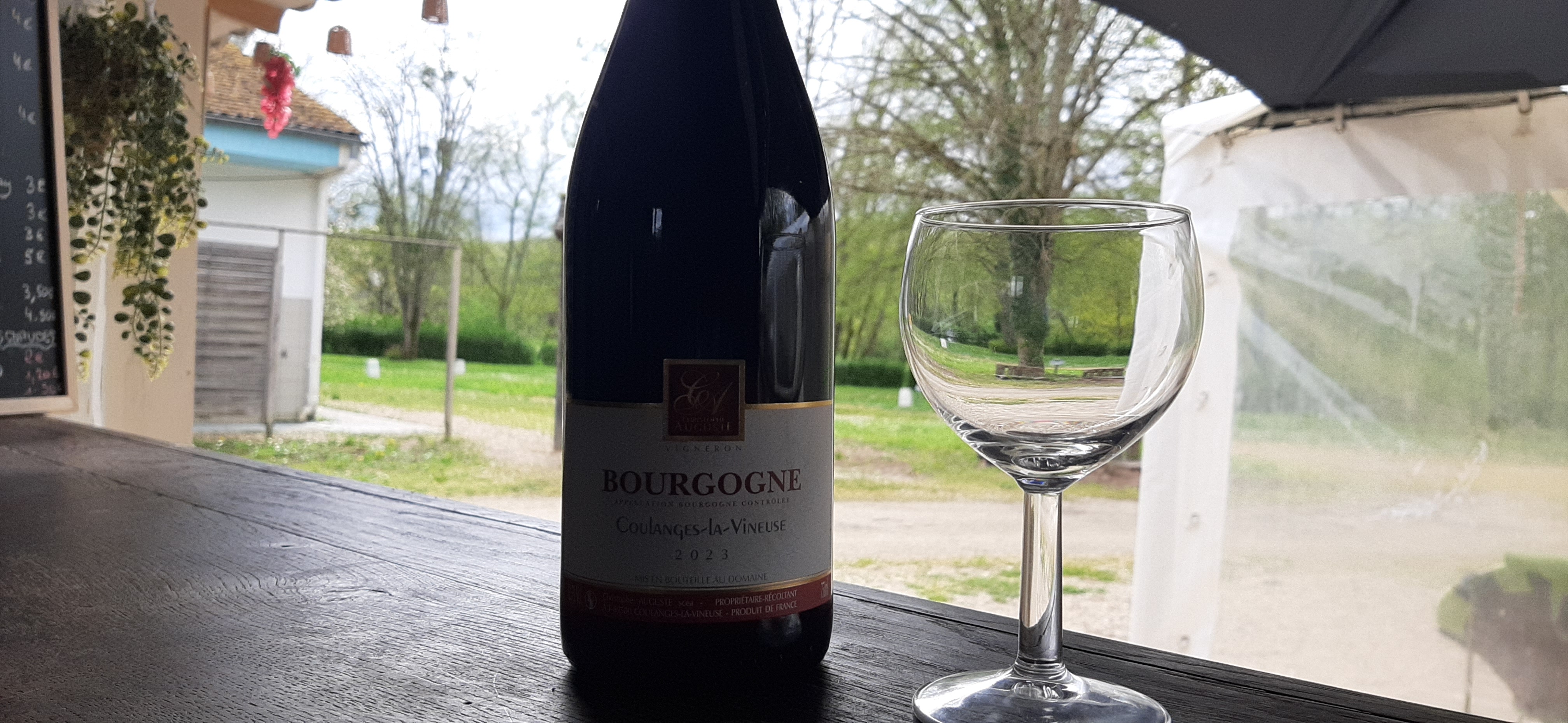 Photo d'une bouteille de vin rouge Bourgogne Coulange et un verre à vin